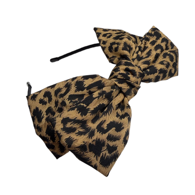 schreibe einen emotionalen verkaufsstarken Titel und text für Onlineshop. Haarreif,oben Mitte Masche, animalprint. Rockabilly. Mit Vorteilen. Schreibe nichts von gepolstert oder bequem. Mehrere titel vorschläge.